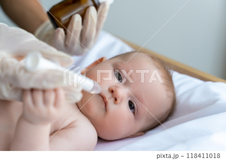 Nurse giving medication to sick kid during a visit to the healthcare clinic 118411018
