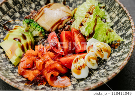 Colorful salad bowl with fresh vegetables, avocado, eggs, and sauce - healthy and vibrant meal Colorful salad bowl with fresh vegetables, avocado, eggs, and sauce - healthy and vibrant meal 118411049