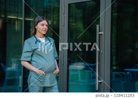 Pregnant woman in lab coat walking in front of the clinic 118411203