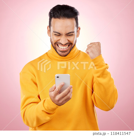 Winner, man and phone for success, yes and celebration of online news, social media or gaming results. Excited, mobile games and person reading notification or website bonus on pink studio background 118411547