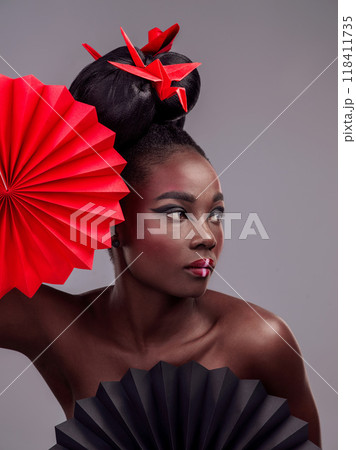 Beauty, makeup and origami with black woman in studio for creative, art and culture. Traditional, cosmetics and paper design with female model and fans on grey background for oriental, retro or color Beauty, makeup and origami with black woman in studio for creative, art and culture. Traditional, cosmetics and paper design with female model and fans on grey background for oriental, retro or color 118411735