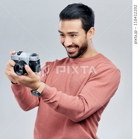 Camera, photography and happy with asian man in studio for photoshoot, satisfaction and creative. Vintage, photographer and production with male on white background for shooting, lens and hobby 118412202