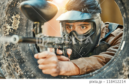 Paintball, shooting and man in action with gun for tournament, competition and battle in nature. Camouflage, military and male person aim in outdoor arena for training, adventure game or challenge 118412214
