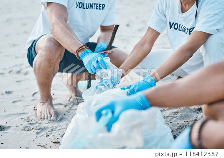 Volunteer, hands of people cleaning beach for world earth day with nature care and kindness for natural environment. Help, recycling and ngo team picking up plastic waste and pollution on ocean sand. 118412387
