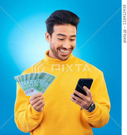 Man, phone and money in studio with prize, esports gambling or happy for success by blue background. Young asian guy, student and smartphone with cash, fintech or crypto with profit, bonus or goals 118412438