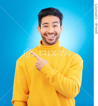 Man, point and smile in studio portrait with choice, fashion and promotion with excited face by blue background. Young Indian guy, gen z student and finger for decision, icon and opinion with clothes 118412471