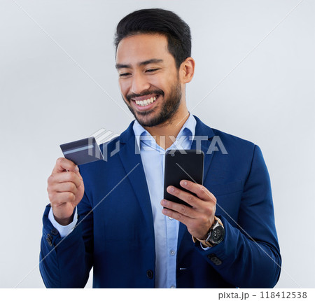 Credit card, phone and smile with man in studio for online shopping, fintech and investment. Banking, ecommerce and app with male on gray background for customer experience, payment and retail 118412538