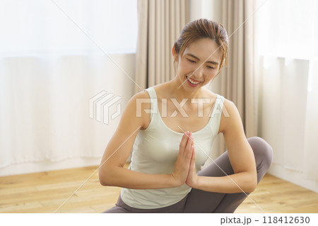 オンラインヨガサロン配信でポーズを見せる若い女性 118412630