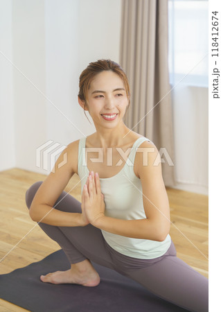 オンラインヨガサロン配信でポーズを見せる若い女性 118412674