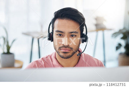 Serious asian man, call center and headset on computer for consulting, customer service or support at office. Focused male consultant with headphones by desktop PC for telemarketing or online advice 118412731