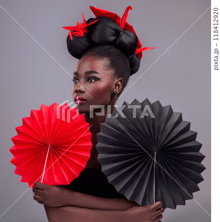 Beauty, cosmetics and origami with black woman in studio for creative, art and culture. Traditional, makeup and paper design with female model and fans on grey background for asian, retro or color Beauty, cosmetics and origami with black woman in studio for creative, art and culture. Traditional, makeup and paper design with female model and fans on grey background for asian, retro or color 118412920