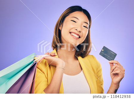 Asian woman, credit card and shopping bag in studio portrait with smile for deal, sale or discount by background. Japanese girl, retail and happy with banking, budget or luxury by purple background Asian woman, credit card and shopping bag in studio portrait with smile for deal, sale or discount by background. Japanese girl, retail and happy with banking, budget or luxury by purple background 118412938