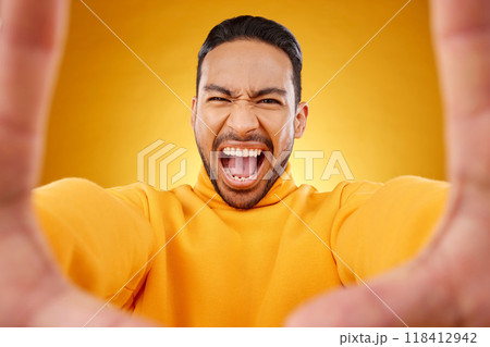 Screaming, portrait and selfie of angry man in studio isolated on a yellow background. Face, shouting and Asian person taking profile picture for memory in anger, frustrated or stress for problem 118412942