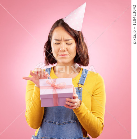 Birthday present, studio box and Asian woman stress over package, ribbon opening fail or party event. Problem, bad gift mistake and Japanese person with doubt, unsure or sad on pink background Birthday present, studio box and Asian woman stress over package, ribbon opening fail or party event. Problem, bad gift mistake and Japanese person with doubt, unsure or sad on pink background 118413042