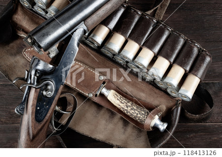 hunting double barreled side shotgun with cartridges in bandolier. hunting double barreled side shotgun with cartridges in bandolier. 118413126