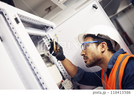 Electrician, engineer and maintenance man with screwdriver in control room for power box. Male technician person for inspection service for engineering, electricity or energy supply repair with torch 118413386