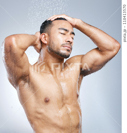 Man in shower with blue background, cleaning and skincare for hygiene with shampoo, healthy body and studio backdrop. Water, skin and hair care, male model washing in bathroom spa with self love. 118413570
