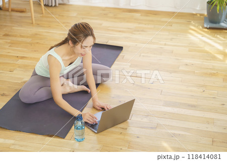 オンラインヨガサロンを自宅で受講している若い女性 オンラインヨガサロンを自宅で受講している若い女性 118414081