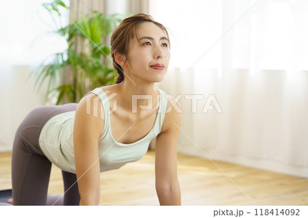 オンラインヨガサロンを自宅で受講している若い女性 オンラインヨガサロンを自宅で受講している若い女性 118414092