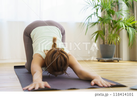 オンラインヨガサロンを自宅で受講している若い女性 オンラインヨガサロンを自宅で受講している若い女性 118414101