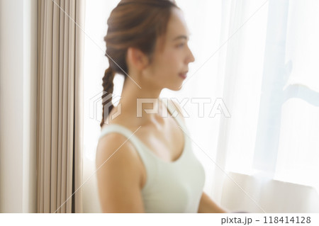 オンラインヨガサロンを自宅で受講している若い女性 オンラインヨガサロンを自宅で受講している若い女性 118414128