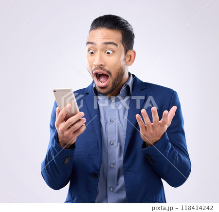 Business man, phone and wow for success in studio for winning, deal or bonus notification. Excited male model isolated on gray background with smartphone mobile app, internet competition or surprise Business man, phone and wow for success in studio for winning, deal or bonus notification. Excited male model isolated on gray background with smartphone mobile app, internet competition or surprise 118414242