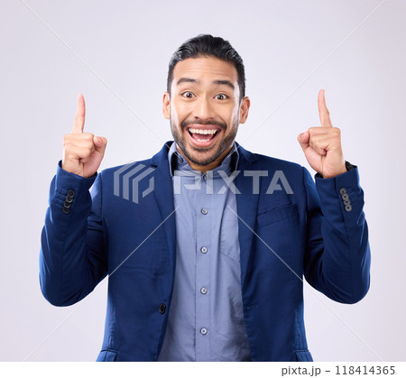 Excited man, business and pointing hands at space in studio for motivation and advertising. Asian male and happy model portrait on gray background with fingers up for mockup promotion announcement 118414365