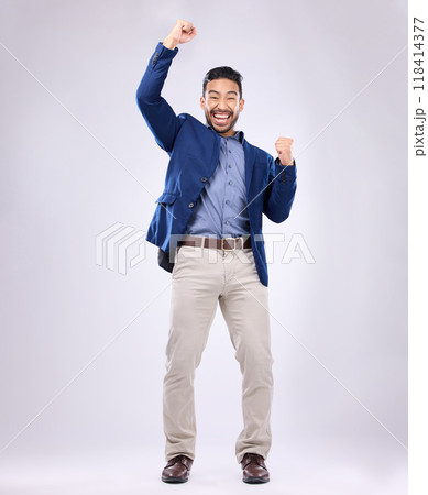 Celebration, excited and portrait of man with fist in air for, happiness, success and bonus on white background. Winner, smile and isolated happy male in studio celebrate winning, good news and deal 118414377
