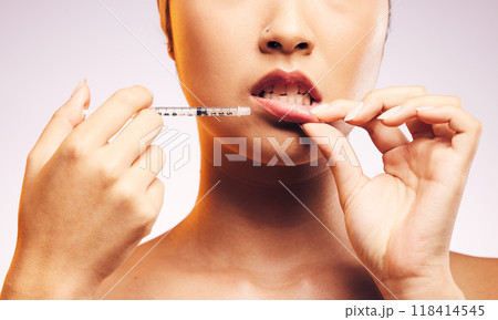 Beauty, lip filler and hands with botox injection, plastic surgery and portrait of cosmetic dermatology in studio background. Lips of woman, syringe and model with aesthetic facial treatment 118414545
