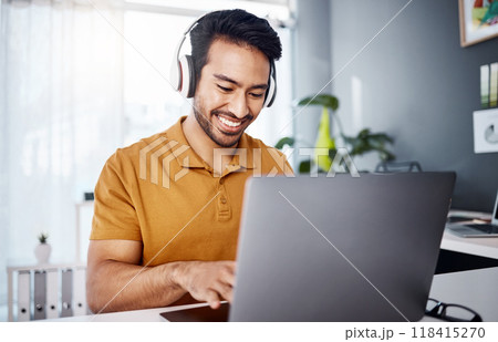 Man is working from home, laptop and headphones while listening to music, happy and busy at desk. Male copywriter typing, freelance and blogger with remote work, technology and online audio streaming 118415270