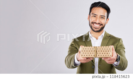 Gift, box and portrait of a man in a studio for a celebration or birthday or event with mockup space. Present, happy and male model from Mexico giving a souvenir with happiness by a gray background. Gift, box and portrait of a man in a studio for a celebration or birthday or event with mockup space. Present, happy and male model from Mexico giving a souvenir with happiness by a gray background. 118415623