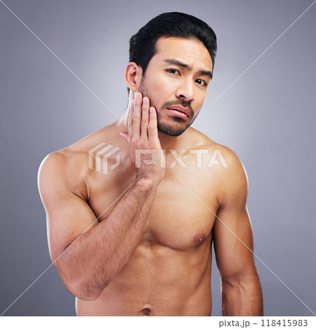 Portrait, skincare and man with beauty, cosmetics and frustrated against a grey studio background. Face, male person and model with grooming routine, unhappy and facial with wellness, shine and sad 118415983