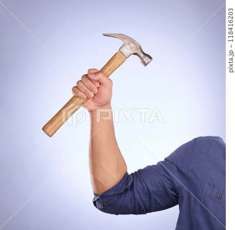 Hammer, construction worker tool and hand in a isolated, blue background and studio. Handyman, house building and maintenance contractor career with man hands holding a builder and repair tools 118416203