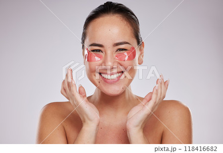 Asian woman, portrait smile and eye patches for skincare cosmetics, collagen or facial against a gray studio background. Happy female smiling in beauty with face mask or patch under eyes for wellness 118416682