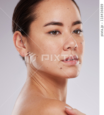Beauty, skincare and face of a woman in studio dermatology and cosmetics for skin glow. Aesthetic asian model person with makeup shine, mole and facial self care for wellness on grey background 118416889
