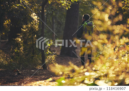 Person, backpacking and hiking in nature forest, trekking woods or trees for adventure, relax workout or fitness exercise. Behind man, walking or hiker in environment, healthcare or morning wellness 118416907