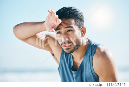 Fitness, sweating and man breathing at the beach after training, running and intense cardio, focus and resting. Face, tired and male runner stop, sweat and breathe during health workout at the sea 118417545