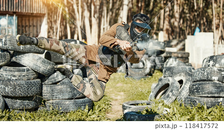 Paintball, sports and man in action with gun for tournament, competition and battle in nature. Camouflage, military and male person shooting in outdoor arena for training, adventure game or challenge 118417572
