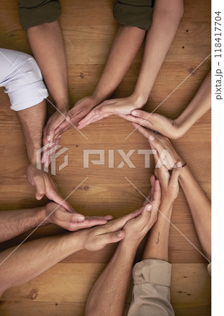 Hands, teamwork and circle with business people on a wooden table in the office closeup from above. Collaboration, synergy and an employee group or team together in a huddle during a meeting at work Hands, teamwork and circle with business people on a wooden table in the office closeup from above. Collaboration, synergy and an employee group or team together in a huddle during a meeting at work 118417704