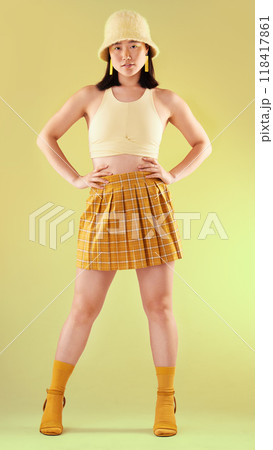 Fashion, gen z and Asian woman in yellow, beauty and streetwear with style on studio background. Trendy, bright aesthetic with model and funky designer brand clothes, stylish female in portrait 118417861