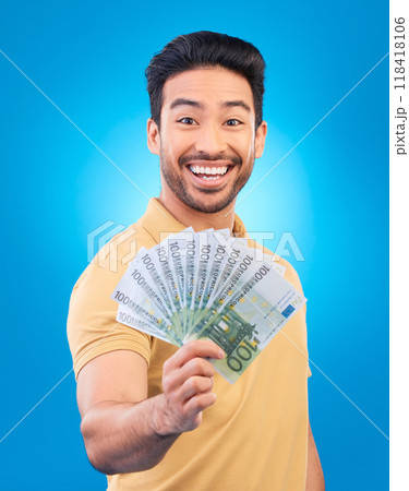Happy man, portrait and money fan for bonus offer, financial success and winning, finance loan or cashback bonus. Young asian person or winner notes or cash profit isolated on studio blue background Happy man, portrait and money fan for bonus offer, financial success and winning, finance loan or cashback bonus. Young asian person or winner notes or cash profit isolated on studio blue background 118418106