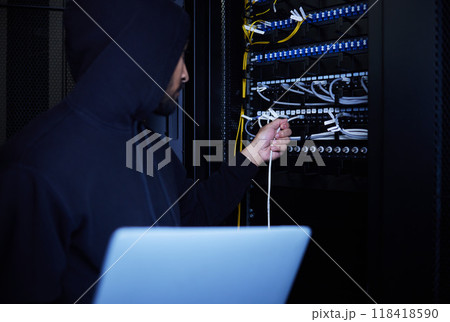 Thief, programming and hacker stealing software, website data and information on server on a laptop. Connection, criminal and man hacking into a network for hardware, coding and cyber crime at night 118418590