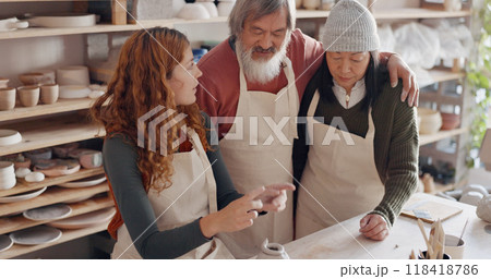 Pottery, teacher and elderly couple in workshop for learning, hobby and skill together. Creative studio, art instructor and people with woman for lesson to mold clay to craft ceramic mug, cup or bowl Pottery, teacher and elderly couple in workshop for learning, hobby and skill together. Creative studio, art instructor and people with woman for lesson to mold clay to craft ceramic mug, cup or bowl 118418786