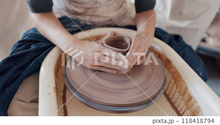 Art, hands and clay on wheel to mold container or bowl in studio, workshop or class. Artist, person and student with creative, unique pottery or shape for ceramic product design process with care. Art, hands and clay on wheel to mold container or bowl in studio, workshop or class. Artist, person and student with creative, unique pottery or shape for ceramic product design process with care. 118418794