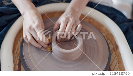 Pottery, wheel and hands to mold clay container in studio, workshop or classroom. Artist, craft and hobby with creativity, unique mug, cup or handmade ceramic bowl with design and process from above Pottery, wheel and hands to mold clay container in studio, workshop or classroom. Artist, craft and hobby with creativity, unique mug, cup or handmade ceramic bowl with design and process from above 118418799
