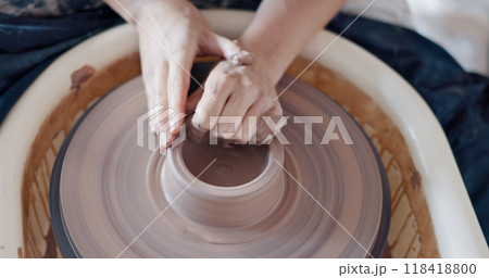 Pottery, wheel and hands to shape clay container in studio, workshop or classroom. Artist, craft and hobby with creativity, unique mug, cup or handmade ceramic bowl with design and process from above Pottery, wheel and hands to shape clay container in studio, workshop or classroom. Artist, craft and hobby with creativity, unique mug, cup or handmade ceramic bowl with design and process from above 118418800