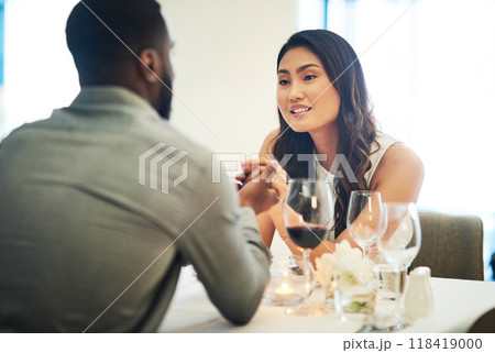 Couple, holding hands and wine in restaurant with talking, love and romance for valentines day date in night. Black man, asian woman and conversation for bonding, luxury fine dining and celebration Couple, holding hands and wine in restaurant with talking, love and romance for valentines day date in night. Black man, asian woman and conversation for bonding, luxury fine dining and celebration 118419000