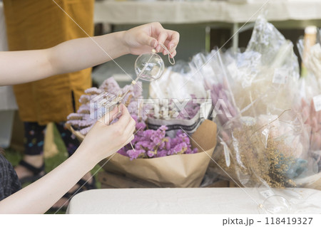 ドライフラワーの着いたおしゃれな風鈴をワークショップで作る若い女性 ドライフラワーの着いたおしゃれな風鈴をワークショップで作る若い女性 118419327