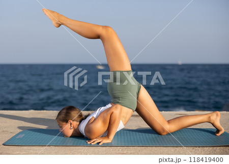 Various yoga poses performed by a sporty girl on sunny seaside Various yoga poses performed by a sporty girl on sunny seaside 118419400