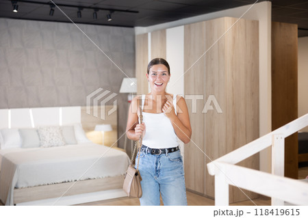 Young girl choosing convenient mattress in furniture shop 118419615
